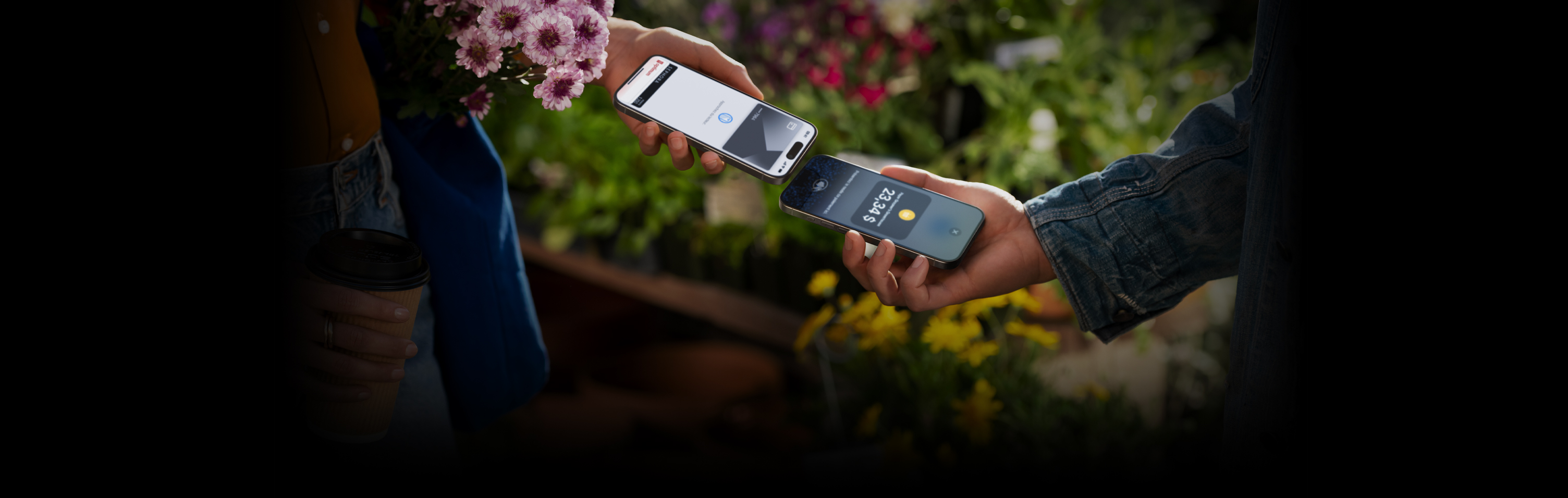 Image de deux personnes tenant leur iPhone l’un près de l’autre pour conclure une transaction.