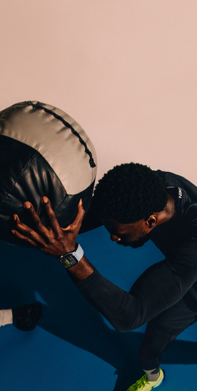 Un homme portant une Apple Watch Series 10 tient un ballon d’exercice durant son entraînement.