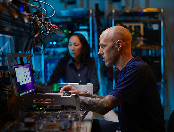 Dois funcionários da equipe de hardware da Apple trabalham em um laboratório.