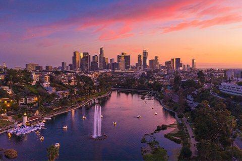 Vista aérea de los rascacielos de Los Ángeles con un parque y un lago en primer plano.