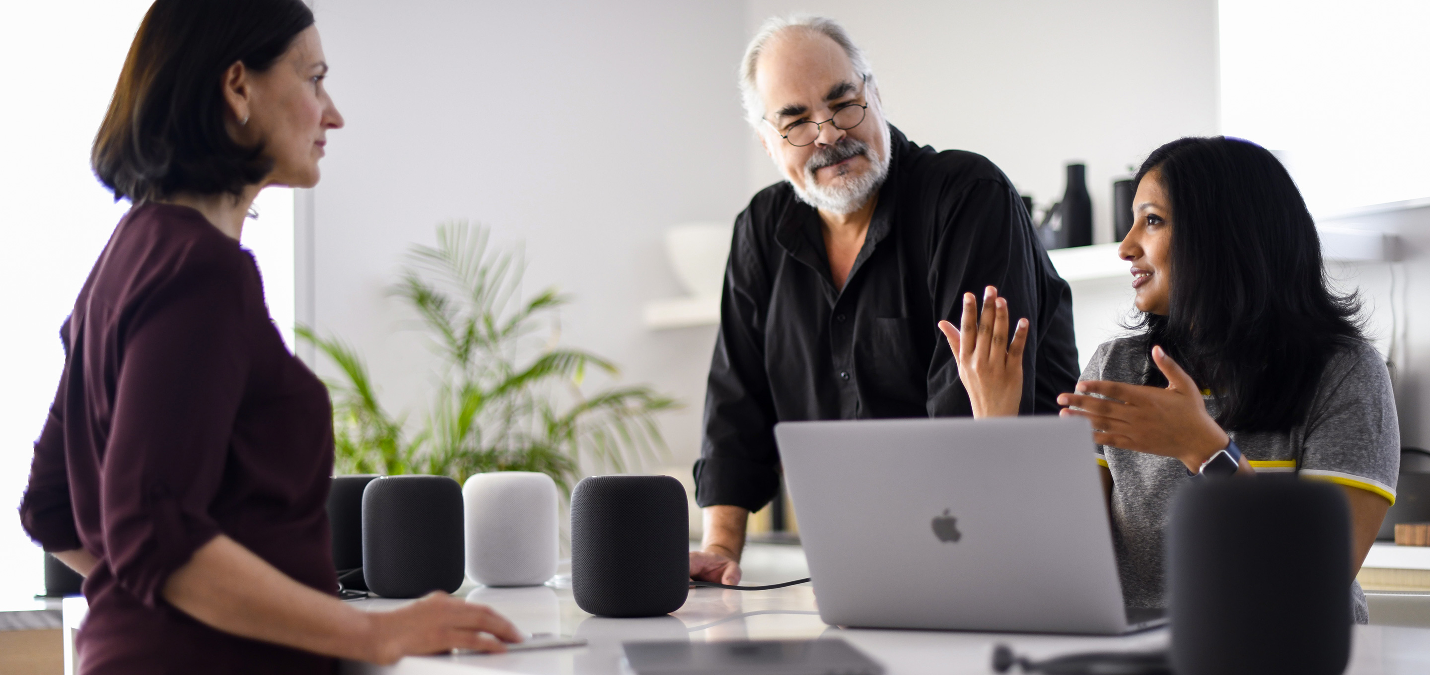 En grupp Apple-medarbetare som jobbar med maskininlärning och AI samtalar på ett kontor.