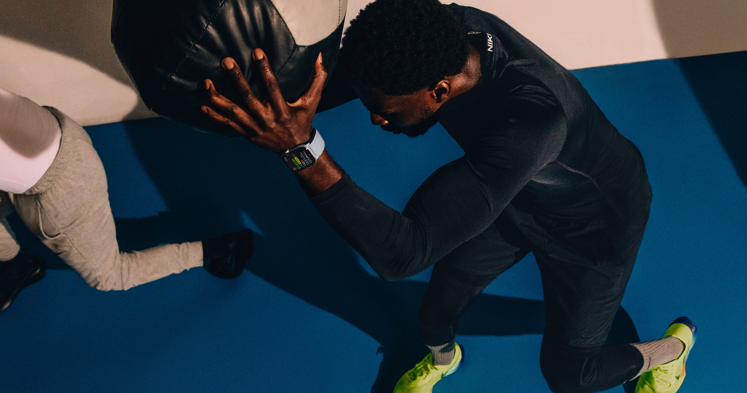 Un hombre que lleva un Apple Watch Series 10 entrena con un balón medicinal.