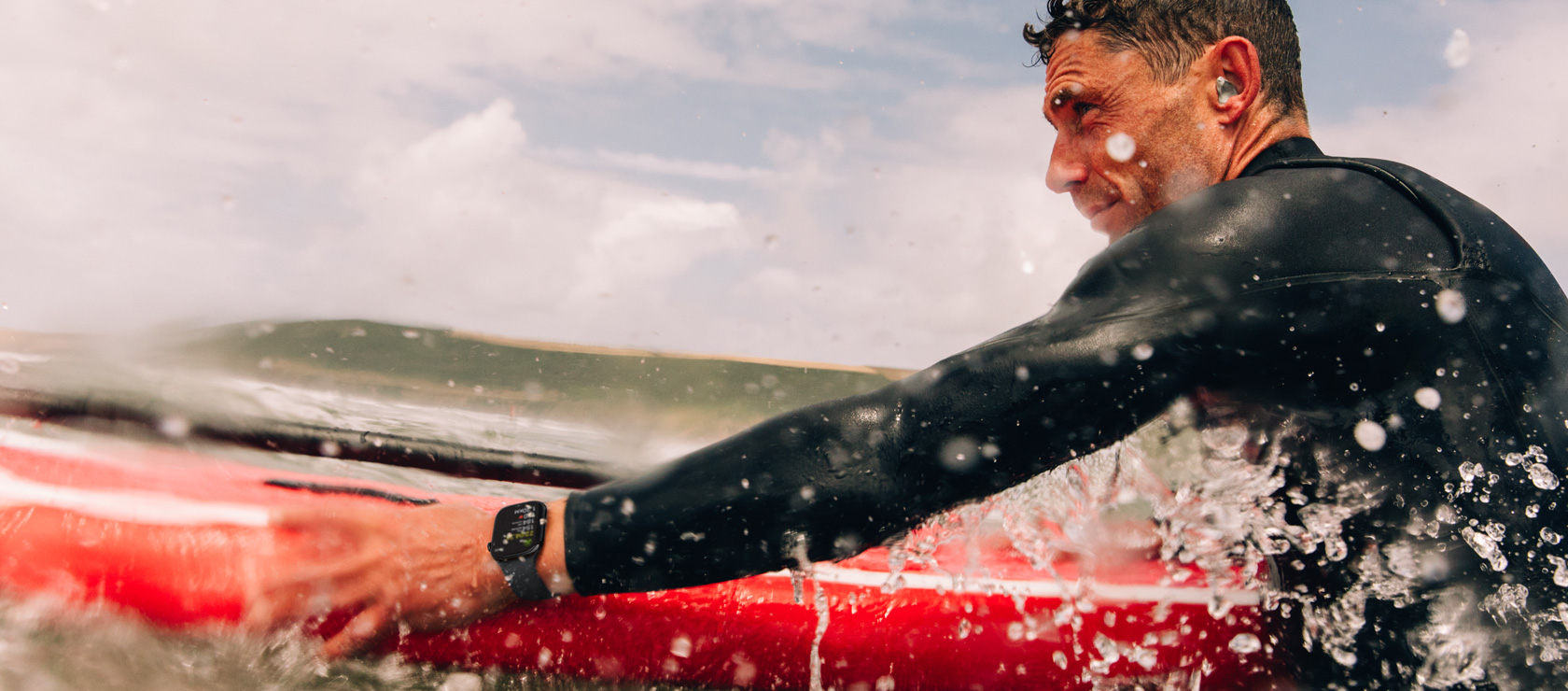 Un hombre con una tabla de paddleboard en el agua lleva puesto un Apple Watch Series 10.