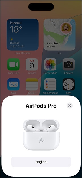 MagSafe Şarj Kutusu'nun içindeki AirPods Pro'nun iPhone'un yanında görünümü. Görselde iPhone'un Ana Ekran'ında bir pencere gösteriliyor, penceredeki bağlan düğmesine basıldığında AirPods'la kolayca eşleşiyor.