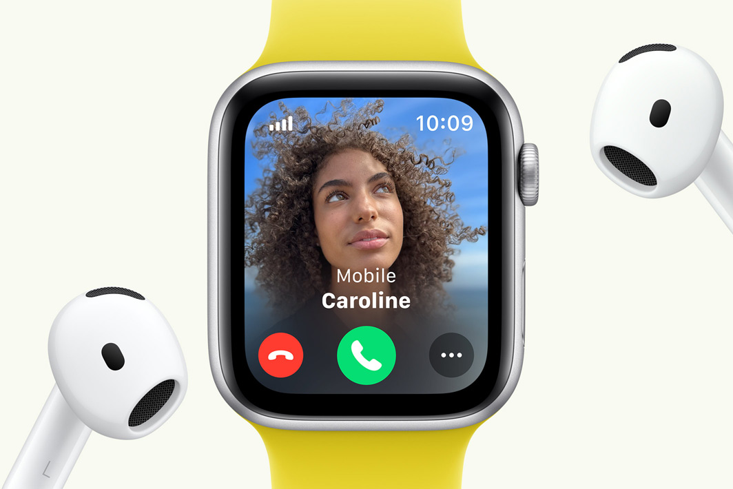 Apple Watch SE showing an incoming call, next to a pair of AirPods