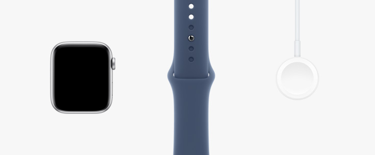 In einer Reihe: Vorderansicht der Apple Watch SE, ein Sportarmband in Polarstern sowie ein magnetisches Ladegerät auf USB‑C Kabel.