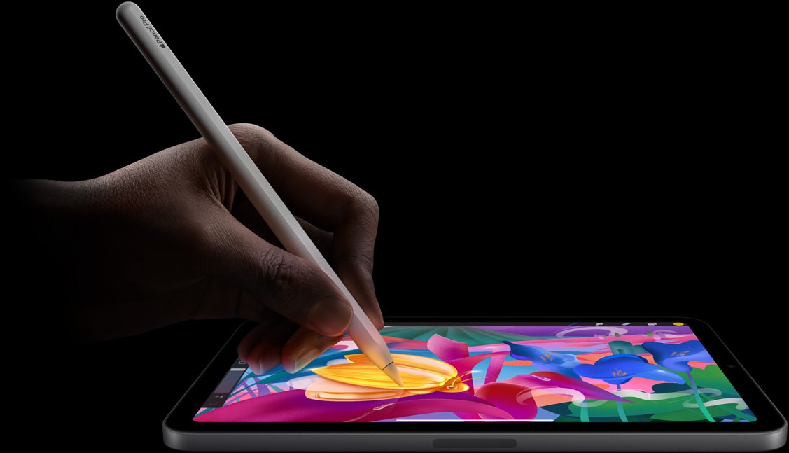 De hand van een gebruiker maakt een kleurrijk kunstwerk met Apple Pencil Pro op iPad mini.