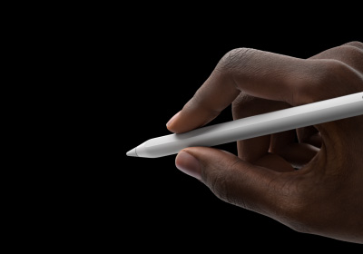 Рука користувача тримає Apple Pencil Pro, ніби готується писати. Кінчик спрямовано в бік інтерфейсу, де показано нову палітру інструментів.