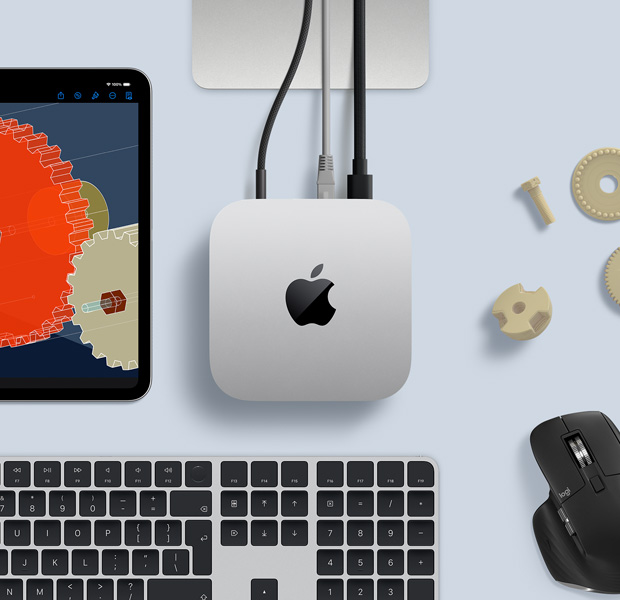 Top view of silver Mac mini in a desk setup with a black-and-silver wireless keyboard, a black wireless mouse and an iPad